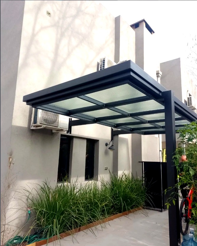 Pérgola de vidrio con muebles de jardín de día
